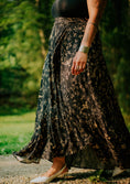 Load image into Gallery viewer, Person wearing a long, dark floral skirt in an outdoor setting