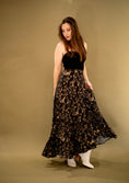 Load image into Gallery viewer, woman wearing a black and gold flowy skirt on a green gold backdrop.
