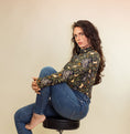 Load image into Gallery viewer, woman sitting on a chair in a studio wearing a mouse printed turtleneck and blue jeans.