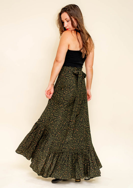Woman wearing a long, patterned skirt with a plain background